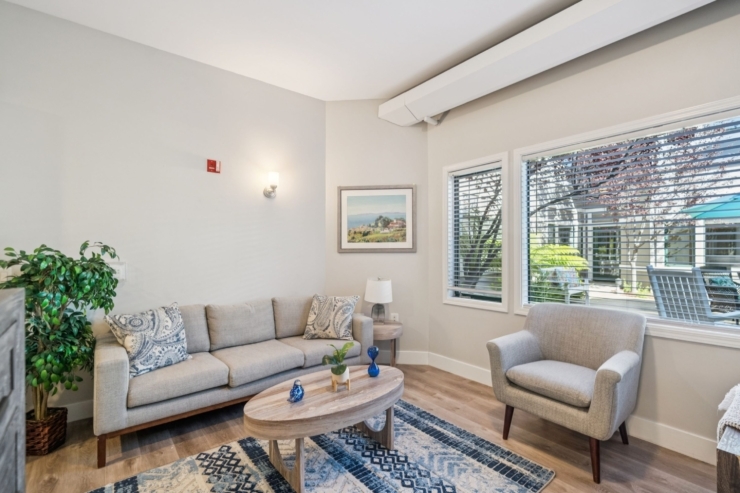 A cozy lounge area features comfortable seating, inviting decor, and bright, welcoming natural light.