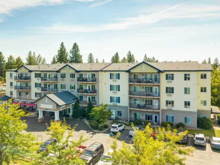 Bright and welcoming retirement community surrounded by trees with comfortable balconies and ample parking.