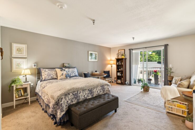 Bright and inviting space, featuring a comfortable bed, cozy seating, and a serene outdoor view.