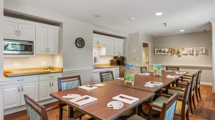 A welcoming activity room, featuring a large table set for creativity, surrounded by cheerful artwork.