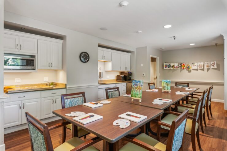 A welcoming activity room, featuring a large table set for creativity, surrounded by cheerful artwork.