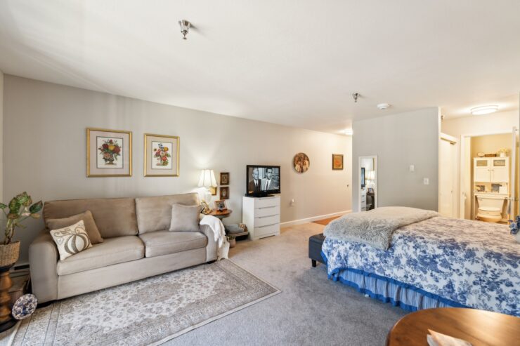 A bright, inviting room features comfortable furnishings, personal touches, and a warm atmosphere, perfect for relaxation and community.