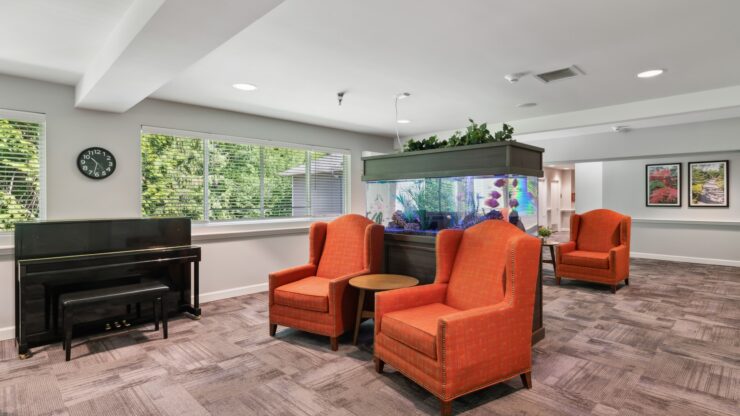 Bright and inviting, this lounge features comfortable seating, a piano, and a vibrant aquarium, fostering community.
