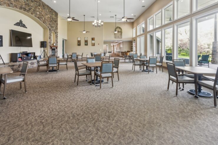 Bright, spacious gathering area with inviting tables, perfect for community activities and relaxation.