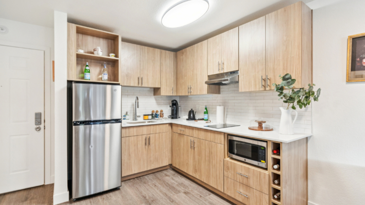 A welcoming kitchen space featuring modern appliances and warm wooden cabinetry, perfect for gathering and comfort.