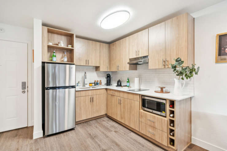 A welcoming kitchen space featuring modern appliances and warm wooden cabinetry, perfect for gathering and comfort.