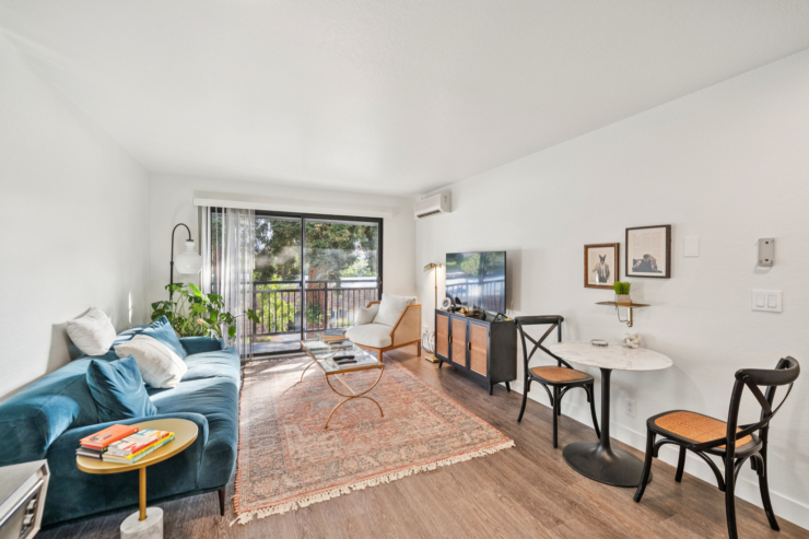 A bright, inviting living space featuring comfortable seating, leafy plants, and warm decor, promoting community and relaxation.