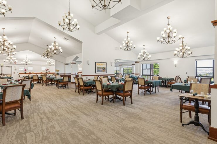 Bright and inviting dining area, featuring elegant chandeliers and comfortable seating for community gatherings.