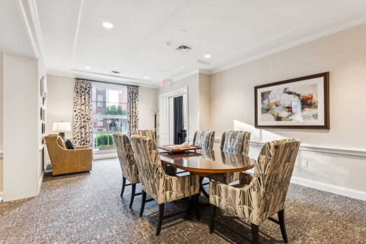 An inviting community space featuring a shared table, comfortable seating, and bright, cheerful decor.