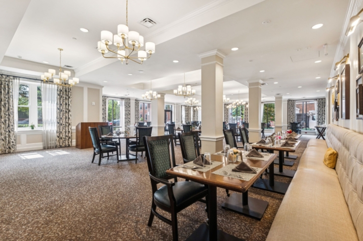 A bright, inviting dining area features comfortable seating and elegantly set tables, fostering community.