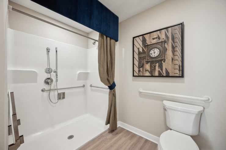 A bright, accessible bathroom featuring safety fixtures and a charming wall clock, promoting comfort and care.