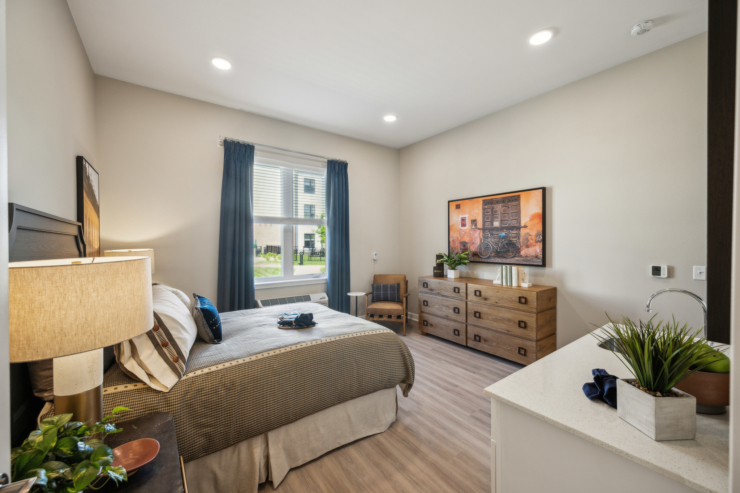 A welcoming bedroom featuring warm lighting, inviting textures, and a peaceful view, perfect for restful living.