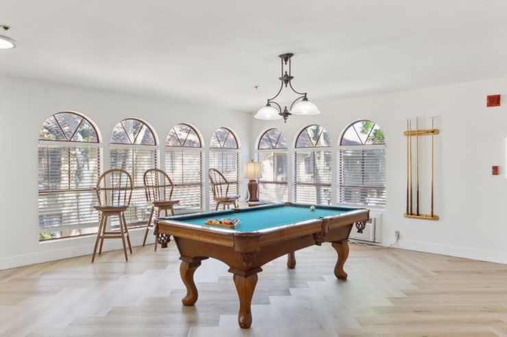 Bright and inviting, this space features a pool table surrounded by natural light, perfect for gatherings.