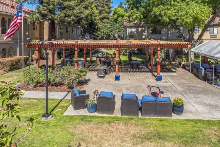 A welcoming outdoor space invites relaxation with comfortable seating and vibrant greenery, perfect for community gatherings.