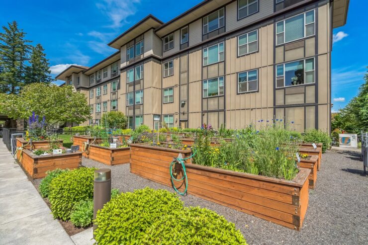 Lush garden beds invite residents to enjoy nature, fostering community and relaxation in a vibrant setting.