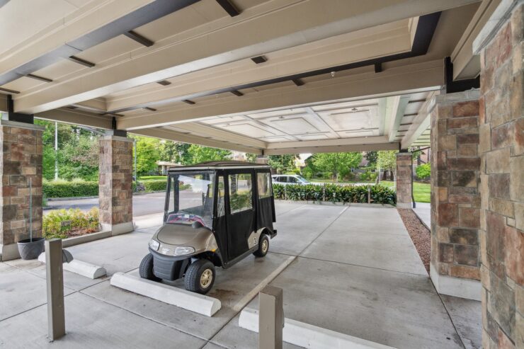 A welcoming entrance with lush greenery and a convenient golf cart, inviting community engagement.