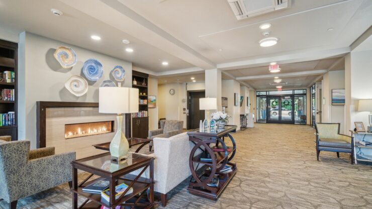 A warm, inviting lobby features comfortable seating, a gentle fireplace glow, and vibrant decor, fostering community.
