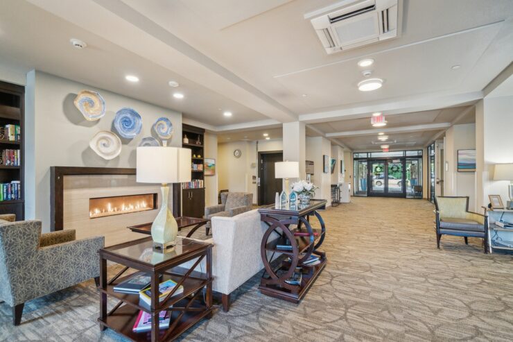 A warm, inviting lobby features comfortable seating, a gentle fireplace glow, and vibrant decor, fostering community.