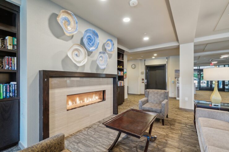 A welcoming lounge features a stylish fireplace, comfortable seating, and vibrant décor, fostering community.