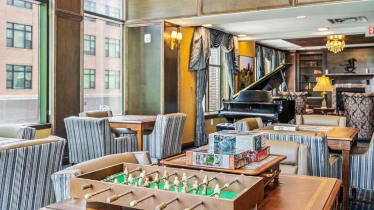 A welcoming lounge filled with games, comfortable seating, and natural light, perfect for community gatherings.