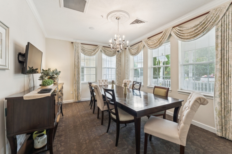 A bright dining area featuring elegant decor, inviting furniture, and large windows for a warm atmosphere.