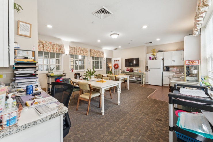 A welcoming communal space filled with natural light, inviting tables, and a warm atmosphere for residents.