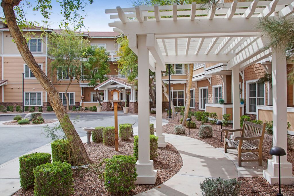 Outdoor seating area with shaded walkway and well-maintained landscaping in a welcoming community setting.