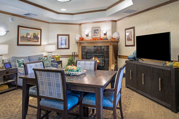 Warm living space with fireplace, comfortable seating, and a dining table for gatherings.