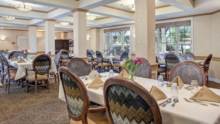 Bright, inviting dining room with elegant seating and fresh flowers, fostering community and comfort.
