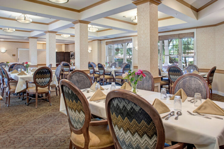 Bright, inviting dining room with elegant seating and fresh flowers, fostering community and comfort.