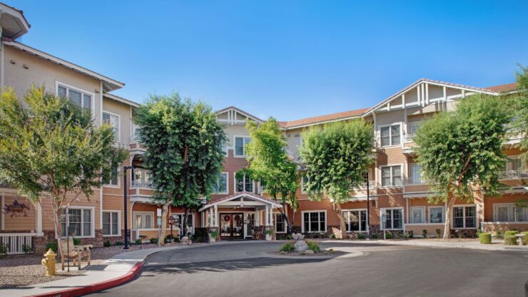 Welcoming retirement community with shaded walkways and comfortable outdoor seating areas.