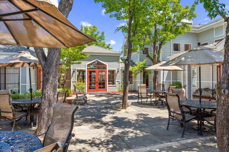 A welcoming courtyard filled with shaded tables invites relaxation and community gatherings.