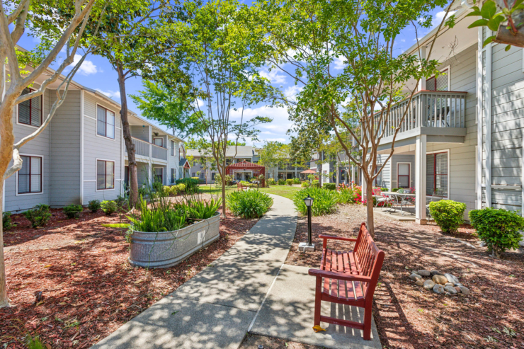 A serene pathway winds through a vibrant garden, inviting residents to enjoy nature and community.