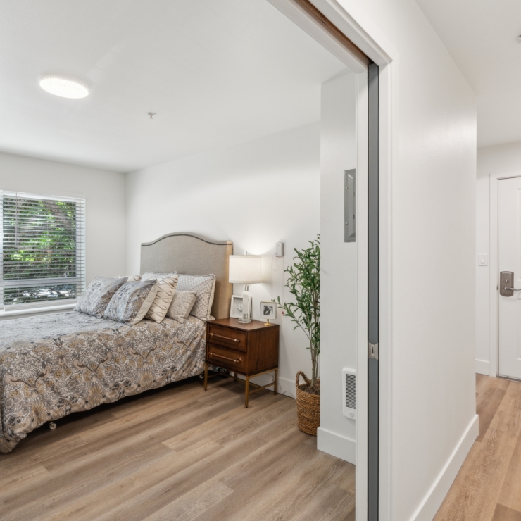 A cozy, bright room with a welcoming bed and warm decor, inviting comfort and community.