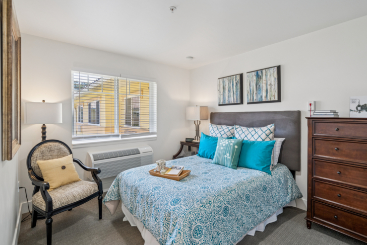 A welcoming bedroom, with soft colors and natural light, offers a serene space for relaxation and community.