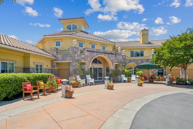 Welcoming entrance with vibrant seating and lush greenery, fostering a warm community atmosphere.
