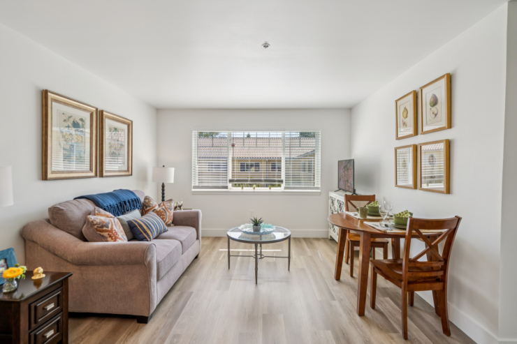 Inviting living space with natural light, featuring a comfortable sofa and a dining area for socializing.
