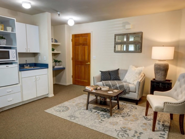 Bright and inviting, this cozy living space features comfortable seating and warm decor, fostering community.