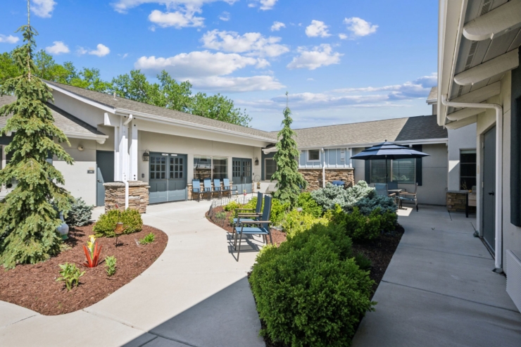 A serene courtyard with lush greenery invites community gatherings and relaxation under bright skies.