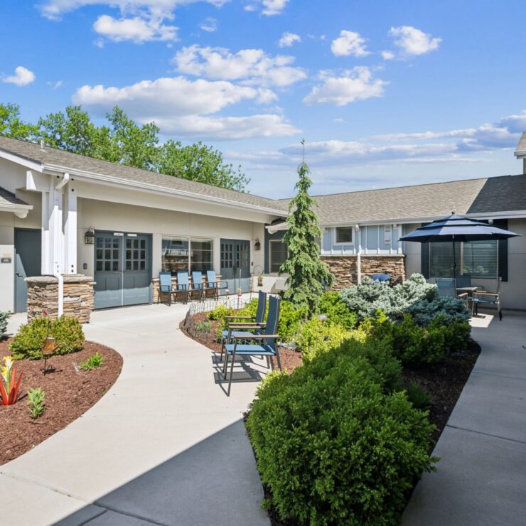 A serene courtyard with lush greenery invites community gatherings and relaxation under bright skies.