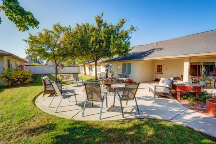 A serene courtyard featuring comfortable seating, vibrant greenery, and a soothing fountain invites community and relaxation.