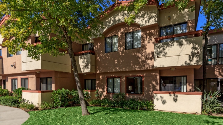 A sunny, welcoming community with lush greenery, inviting residents to enjoy a peaceful, homey atmosphere.