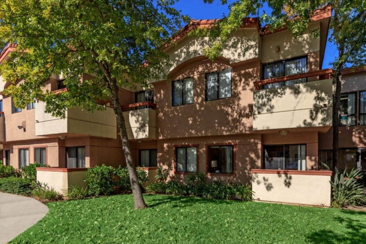 A sunny, welcoming community with lush greenery, inviting residents to enjoy a peaceful, homey atmosphere.