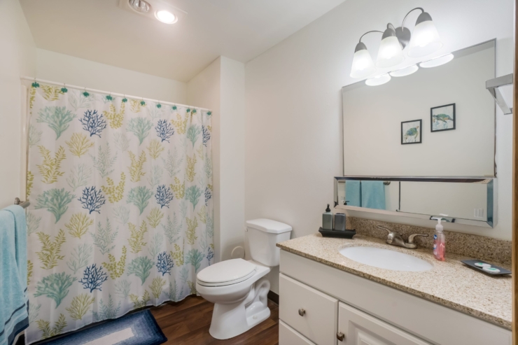 A bright, welcoming bathroom featuring coastal decor and essential amenities for comfort and ease.