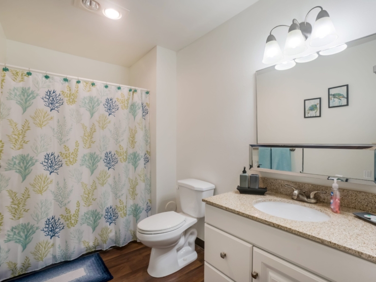 A bright, welcoming bathroom featuring coastal decor and essential amenities for comfort and ease.