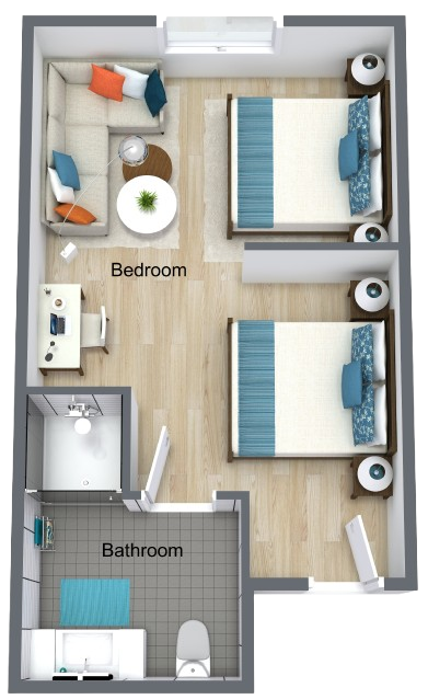 Well-lit companion suite with a bedroom, sitting area, kitchen, and bathroom for independent living.