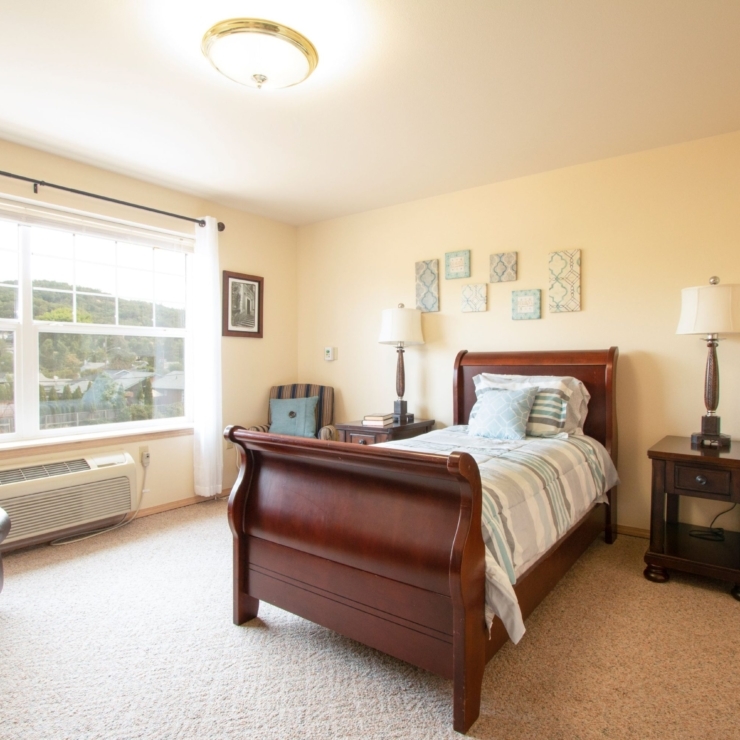 A bright, inviting room with a cozy bed, comfortable seating, and scenic views, perfect for relaxation.