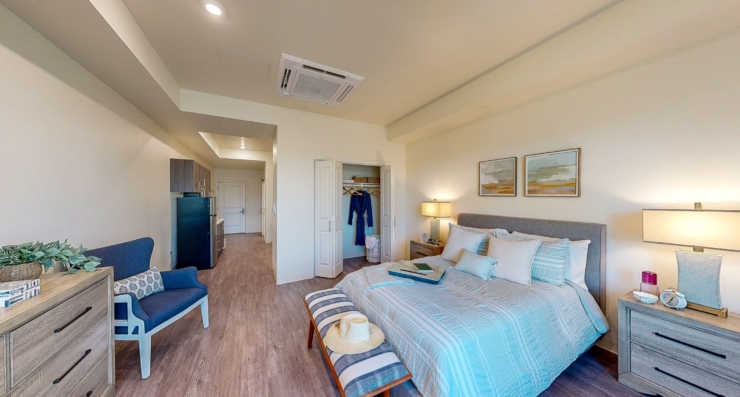 A bright, inviting bedroom featuring soft decor, perfect for relaxation and community warmth.
