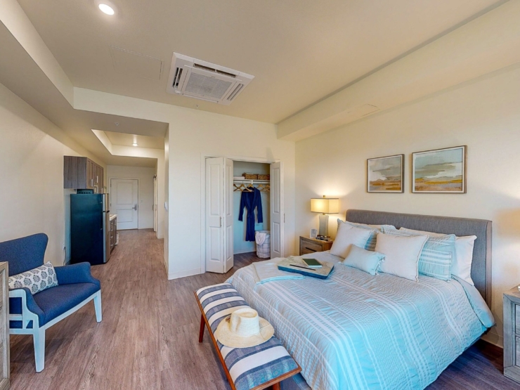 A bright, inviting bedroom featuring soft decor, perfect for relaxation and community warmth.