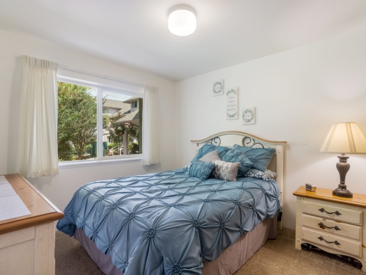 Inviting bedroom with soft decor, natural light, and a serene view, perfect for restful living.